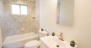 Full bathroom featuring vanity, toilet, and tiled shower / bath