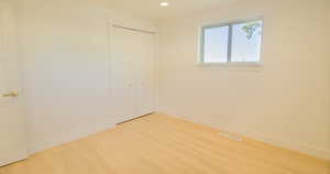 Unfurnished bedroom with wood-type flooring and a closet