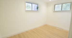 Unfurnished room with a wealth of natural light and hardwood / wood-style floors