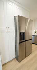 Kitchen featuring white cabinets, stainless steel appliances, and light hardwood / wood-style floors