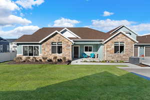 Craftsman-style home featuring a front yard, cooling unit, and a garage