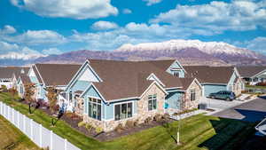 View of front of property featuring central AC unit, a front yard, and a mountain view