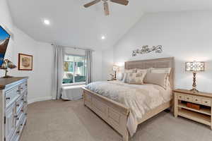 Carpeted bedroom with lofted ceiling and ceiling fan