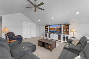 Living room featuring carpet flooring, ceiling fan, and vaulted ceiling