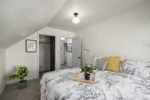 Bedroom with a closet, carpet, and vaulted ceiling