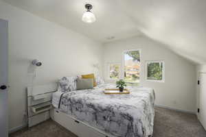 Carpeted bedroom featuring lofted ceiling