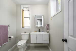 Bathroom with plenty of natural light, vanity, and toilet