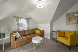 Living room with carpet floors and vaulted ceiling