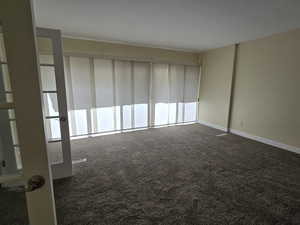 Unfurnished room featuring dark carpet