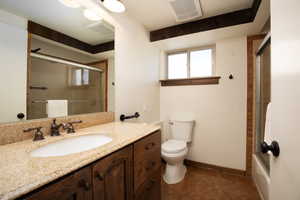 Full bathroom featuring toilet, combined bath / shower with glass door, vanity, and tile patterned floors