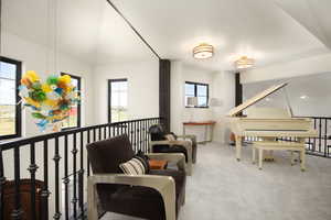 Sitting room featuring light carpet and a healthy amount of sunlight