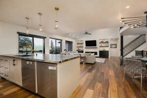 Kitchen with white cabinets, sink, ceiling fan, dark hardwood / wood-style floors, and pendant lighting