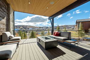 Deck with an outdoor living space with a fire pit and a mountain view