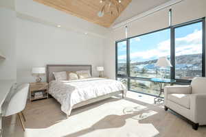 Bedroom with lofted ceiling, wooden ceiling, a mountain view, and light hardwood / wood-style flooring