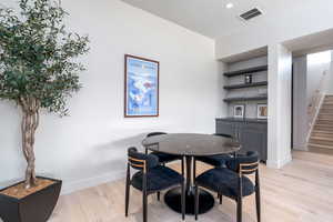 Dining space with bar and light hardwood / wood-style flooring