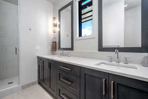 Bathroom with vanity, tile patterned flooring, and an enclosed shower