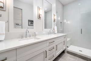 Bathroom featuring tile patterned flooring, vanity, and a shower with shower door