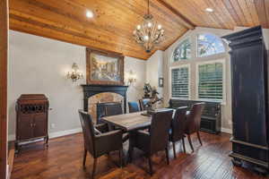 Dining room with gas fireplace, wood floor and vaulted ceiling.