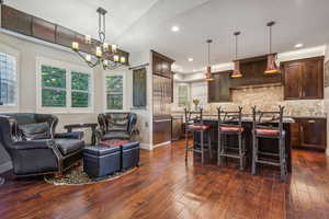 Sit in kitchen with vaulted ceiling, wood floors and plantation shutters