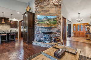 Family room with vaulted ceiling, wood floors and stone wall feature.