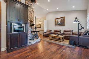 Family room with vaulted ceiling, wood floors and stone wall feature.