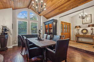 Step down dining room with gas fireplace, wood floor and vaulted ceiling.