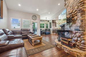 Family room with vaulted ceiling, wood floors, stone wall feature and access to large deck.