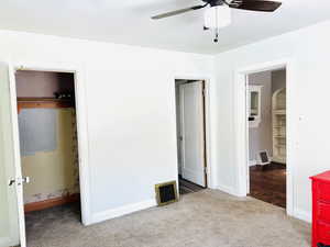 Unfurnished bedroom featuring light carpet, a closet, ensuite bathroom, and ceiling fan