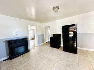 Living room with a fireplace and light tile patterned floors