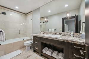 Full bathroom with shower / bath combination with glass door, toilet, vanity, and tile patterned flooring