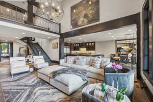 Living room with sink, a chandelier, hardwood / wood-style floors, and a towering ceiling