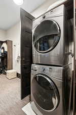 Laundry room with carpet and stacked washer / drying machine