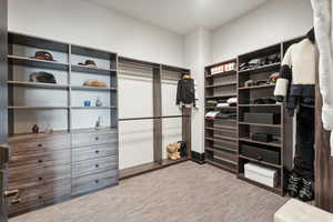 Spacious closet featuring light colored carpet