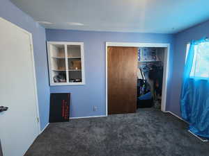 Unfurnished bedroom featuring a closet and carpet floors