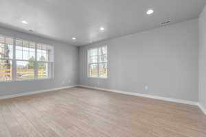 Unfurnished room with a textured ceiling and light hardwood / wood-style flooring