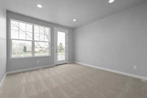 Spare room with a textured ceiling and light carpet