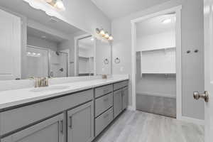 Bathroom with hardwood / wood-style floors, vanity, and an enclosed shower