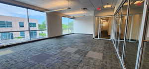 Interior space featuring dark carpet and a paneled ceiling