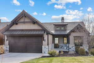 View of front facade with covered porch and a garage