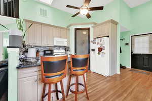 ADU Kitchen featuring tasteful backsplash, cream cabinets, light hardwood / wood-style floors, white appliances, and ceiling fan