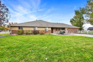 Ranch-style home with a garage and a front lawn