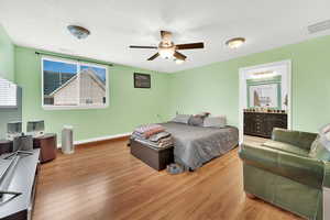 ADU Bedroom with ensuite bathroom, light hardwood / wood-style flooring, and ceiling fan