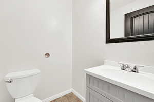 ADU 1/2 Bathroom featuring toilet, vanity, and tile patterned flooring