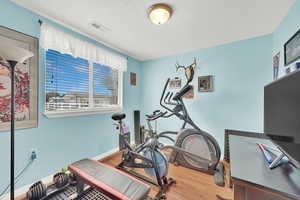 ADU Workout room featuring wood-type flooring and a textured ceiling