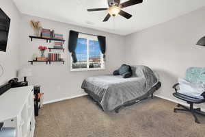 Carpeted bedroom featuring ceiling fan