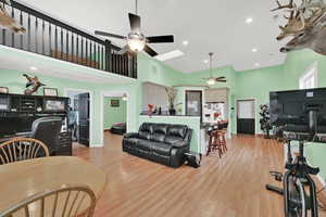 ADU Living room with a high ceiling, a skylight, and light hardwood / wood-style flooring