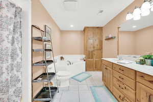 Bathroom featuring toilet, vanity, and tile patterned floors