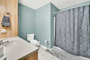 Bathroom featuring toilet, sink, and tile patterned floors