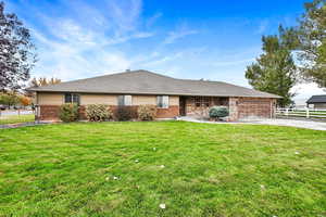 Ranch-style home with a front lawn and a garage