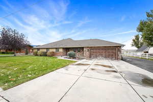 Ranch-style house featuring a garage and a front yard